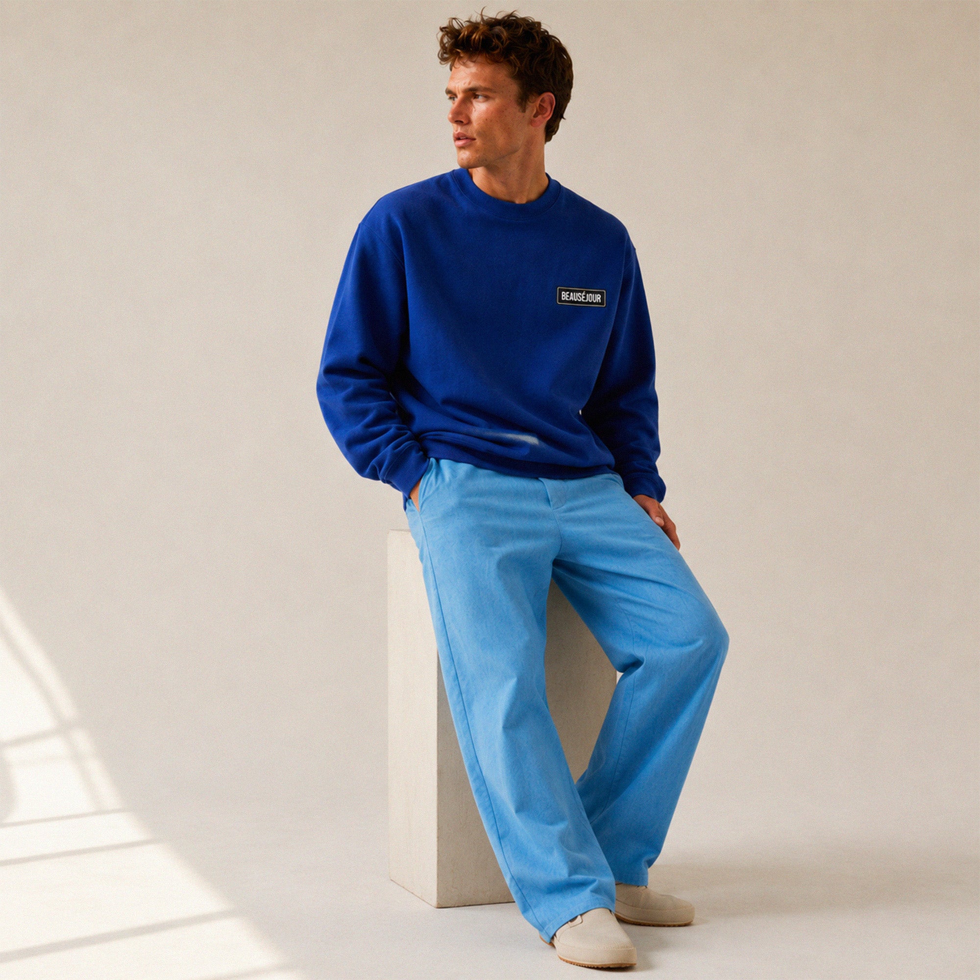Sweatshirt basique Beauséjour® col rond coloris bleu royal, détail du patch Beauséjour noir sur blanc et de la surpiqûre à l'encolure.