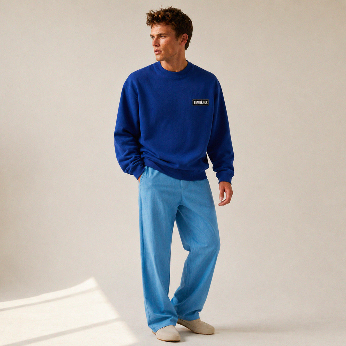 Sweatshirt basique Beauséjour® col rond coloris bleu royal, coton biologique 350g, patch Beauséjour noir sur blanc en poitrine, vue de face.