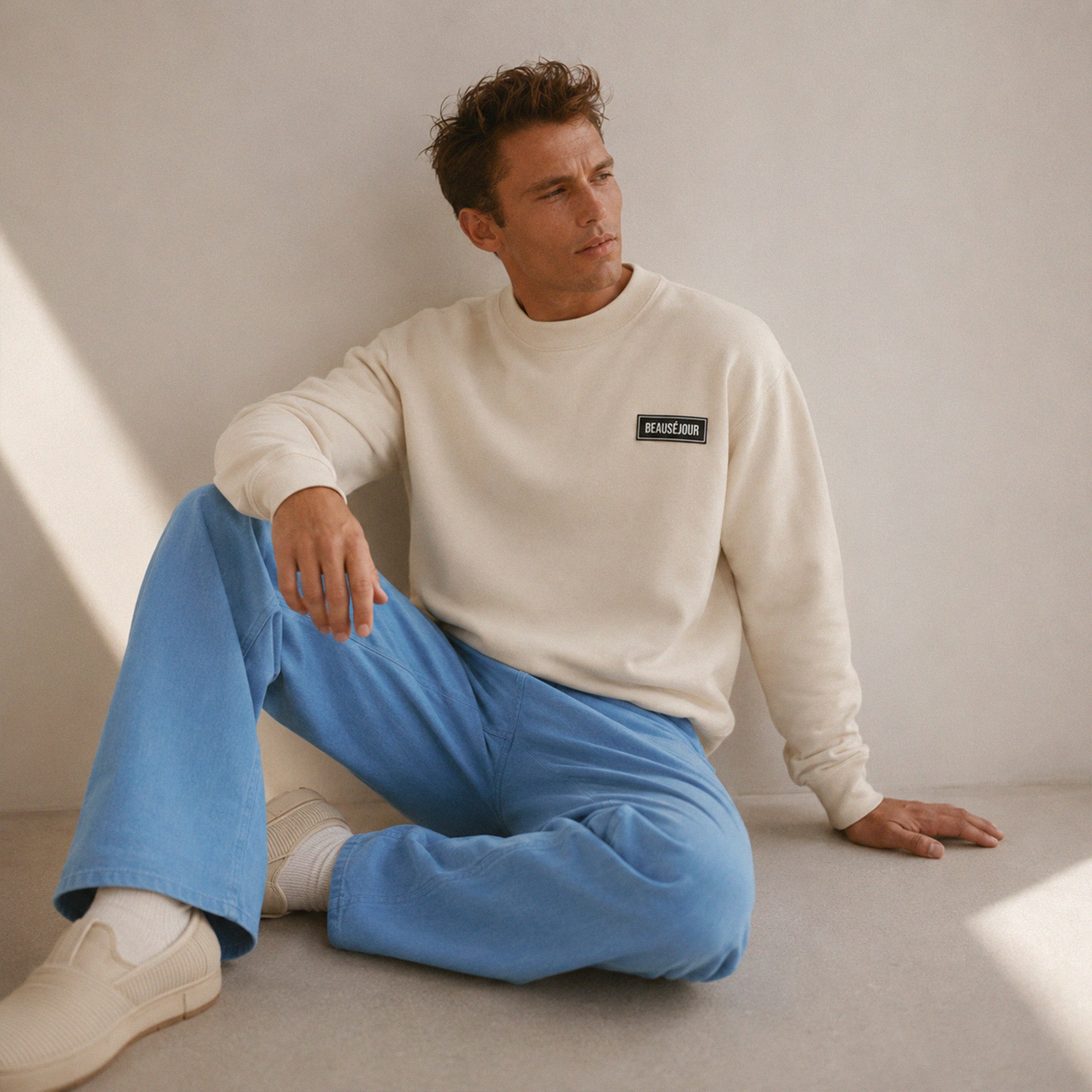 Sweatshirt basique Beauséjour® col rond coloris crème, coton biologique 350g, patch Beauséjour noir sur blanc en poitrine, vue de face.