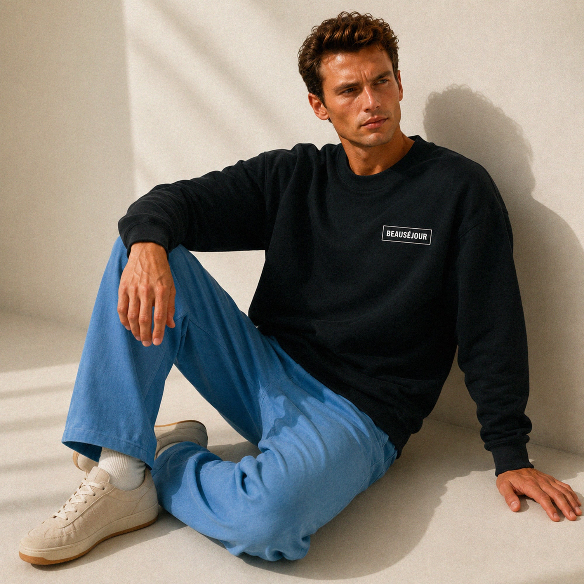 Sweatshirt basique Beauséjour® col rond coloris noir, coton biologique 350g, patch Beauséjour noir sur blanc en poitrine, vue de face.