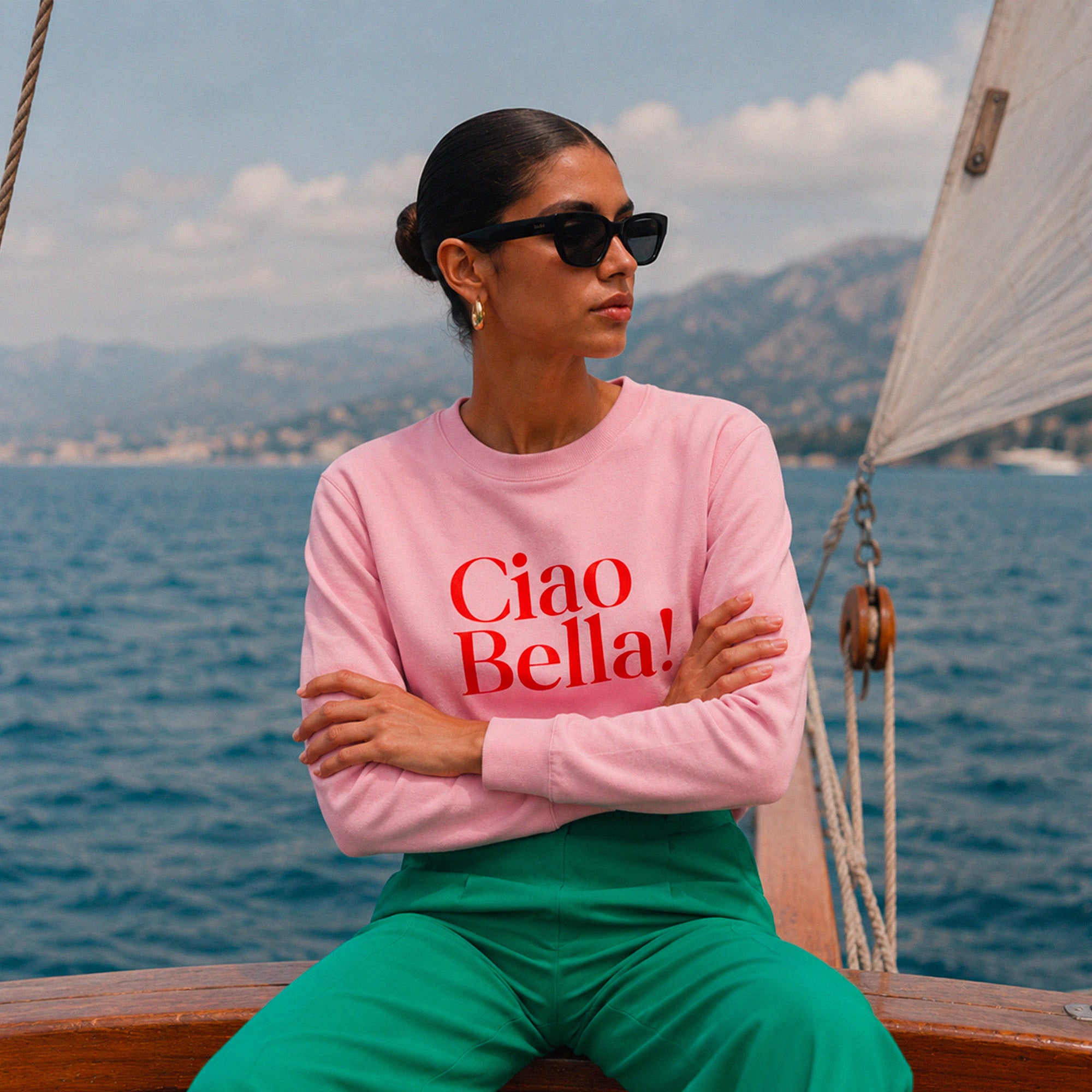 Femme portant un sweatshirt rose Ciao Bella sur un bateau en Mediterranee