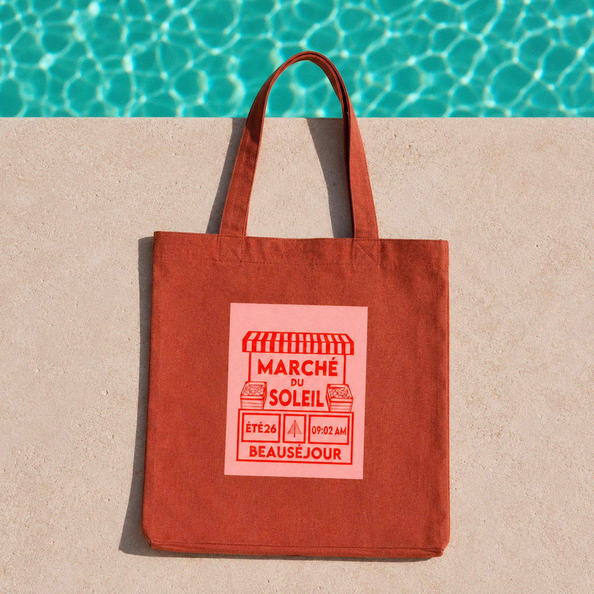 Tote bag terre battue Beauséjour Marché du Soleil avec illustration vintage rouge inspirée des marchés d’été du Sud et de la Côte d’Azur au bord d’une piscine.