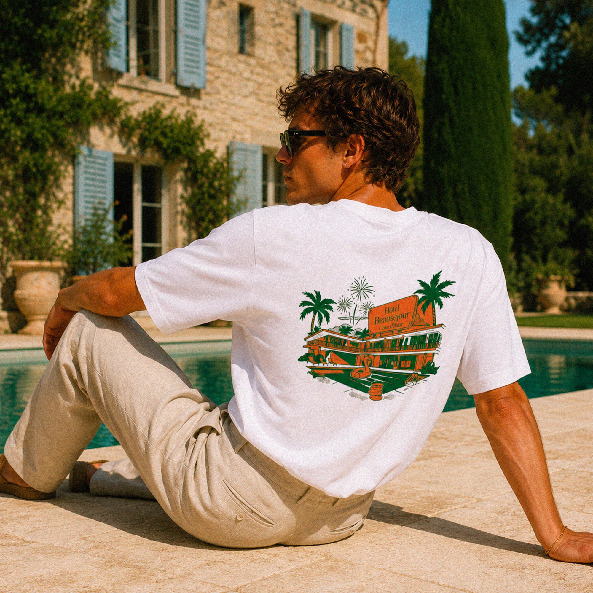 T-shirt boxy blanc Hôtel Beauséjour avec grand imprimé dos inspiration hôtel vintage Côte d’Azur et palmiers.