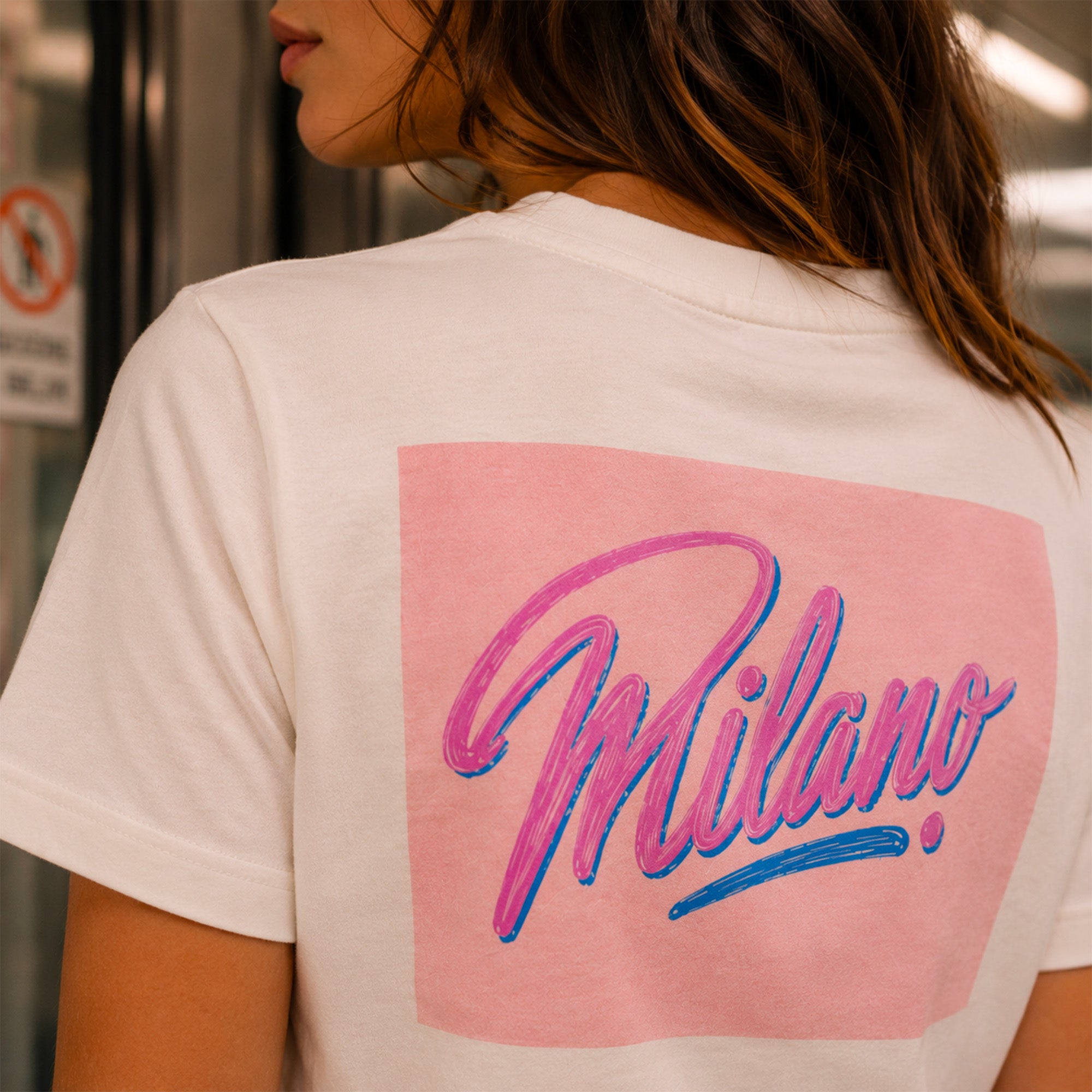 Femme portant un t shirt blanc Milano dans le metro