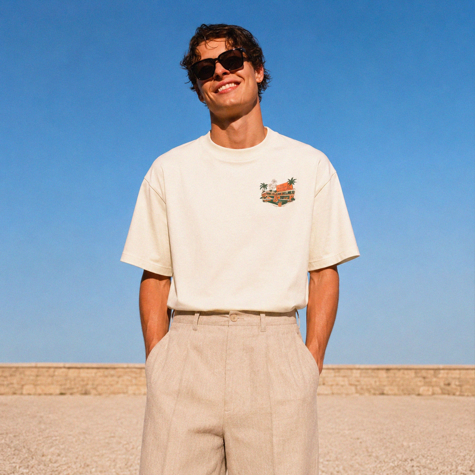 Vue avant du t-shirt crème Beauséjour avec petit imprimé Hôtel côté cœur, coupe boxy premium inspiration Côte d’Azur.