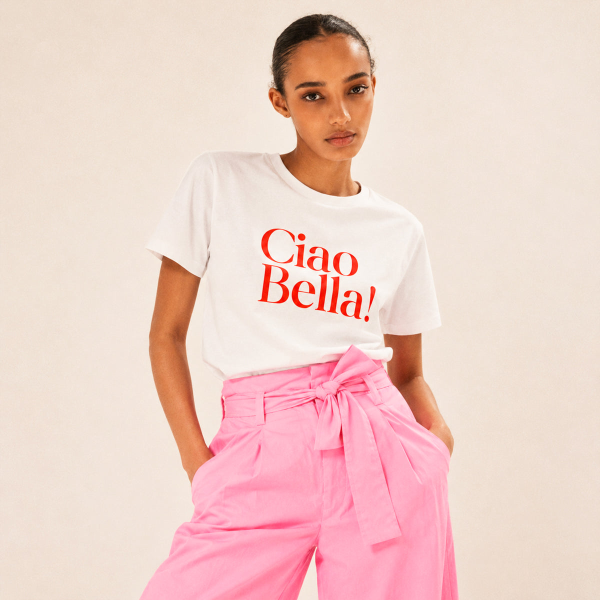 Femme portant un t-shirt blanc Ciao Bella Beauséjour avec inscription rouge. TShirt en coton biologique.