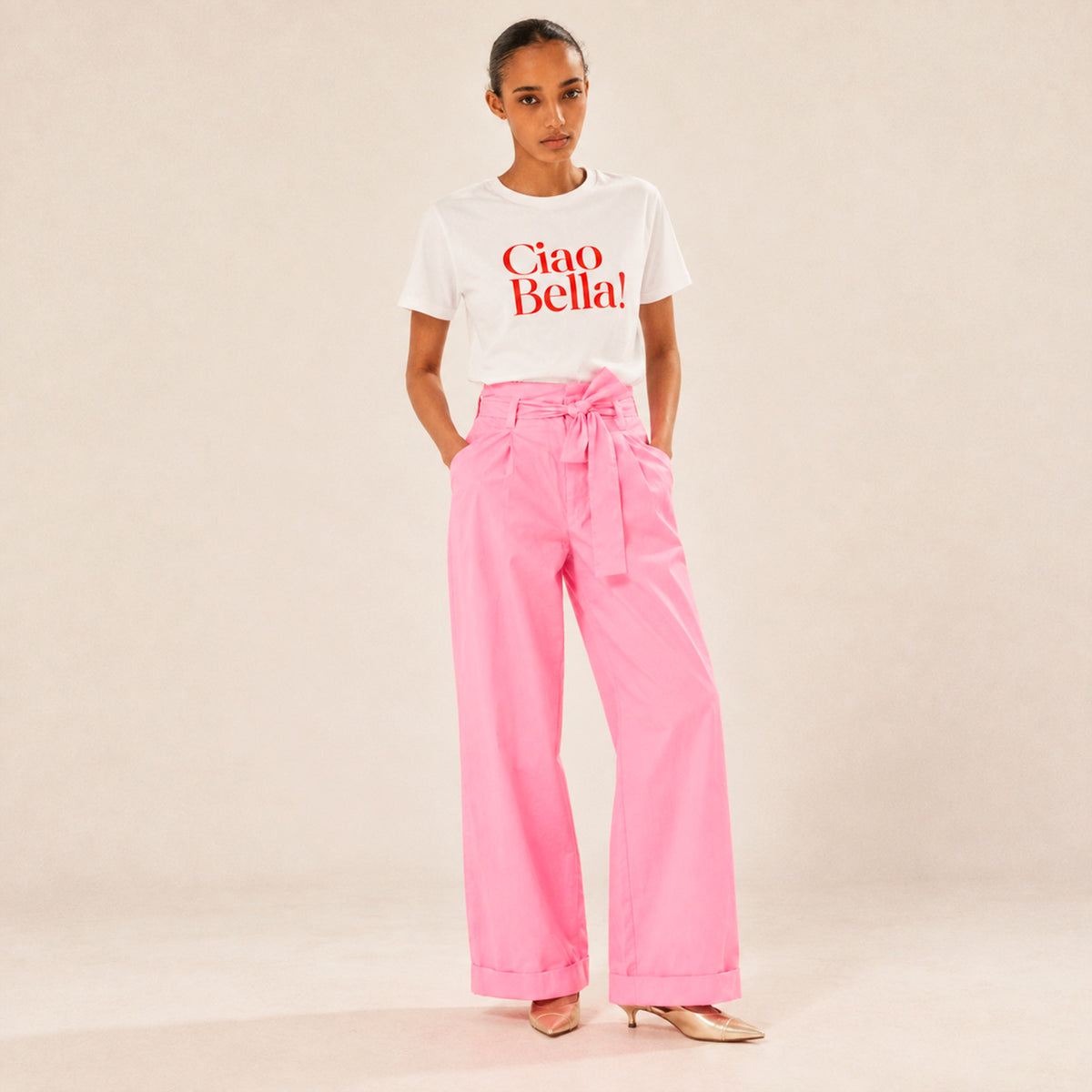 Femme portant un t-shirt blanc Ciao Bella Beauséjour avec inscription rouge.