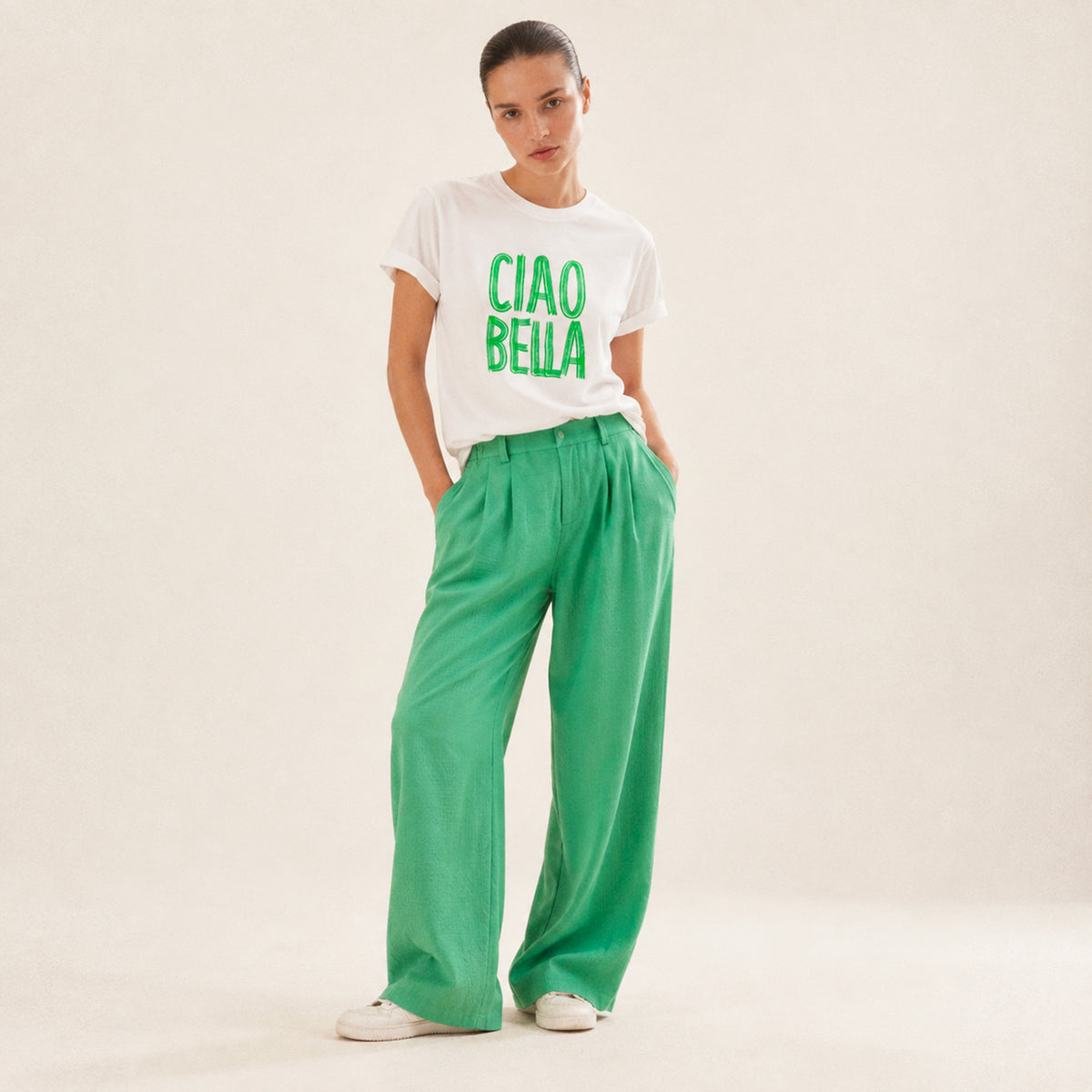 Femme portant un t-shirt blanc Ciao Bella vert Beauséjour avec lettrage vert.