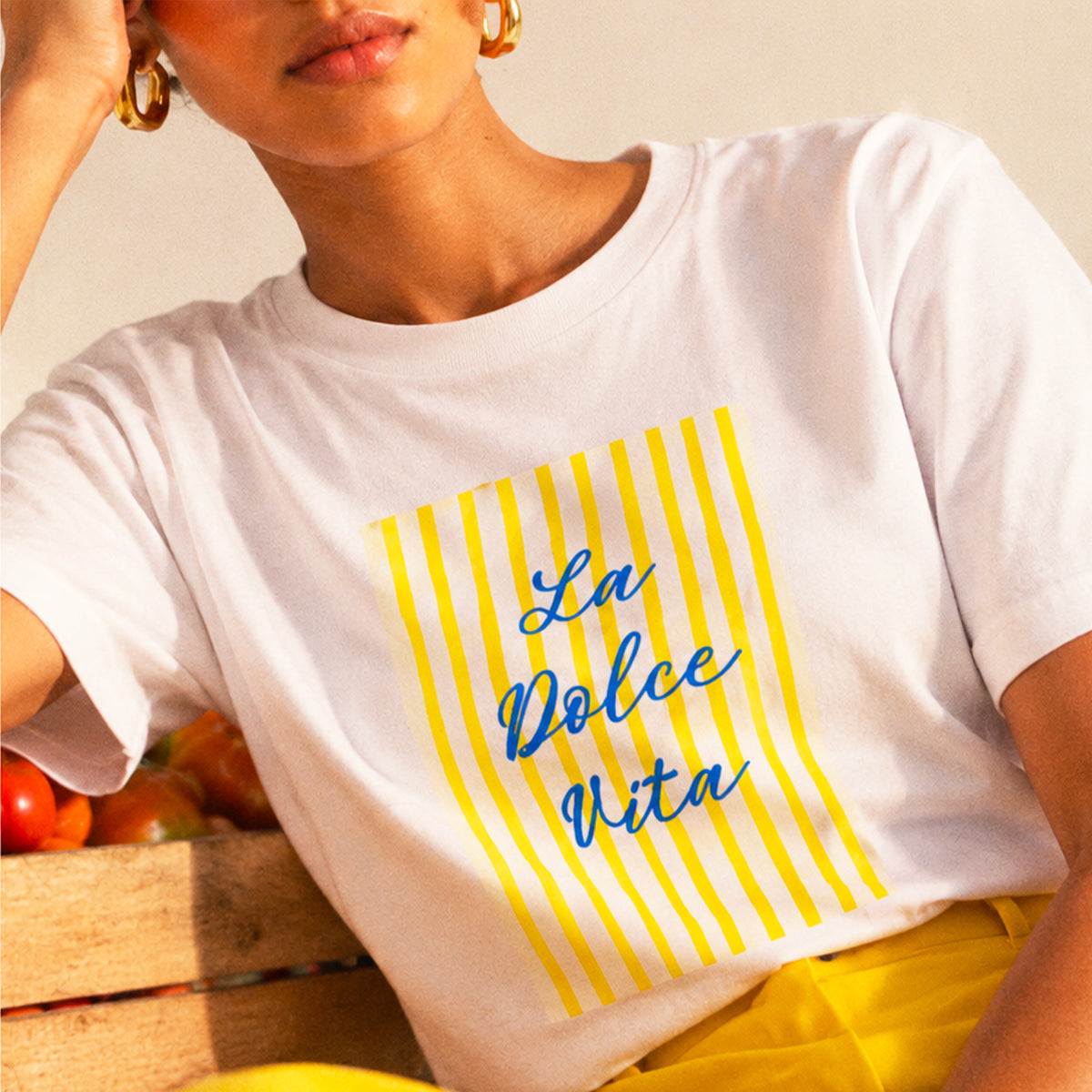 Femme portant un t-shirt blanc La Dolce Vita jaune Beauséjour en coton biologique. Zoom.