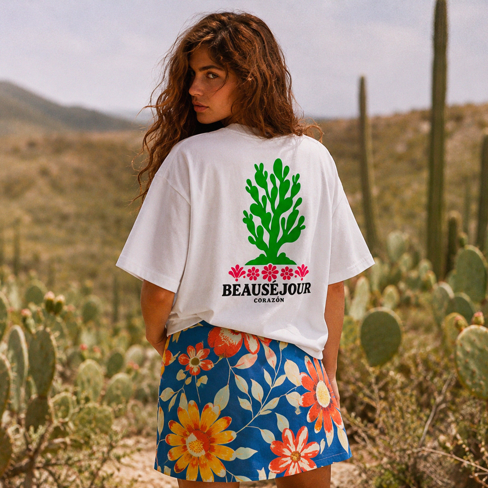 T-shirt boxy blanc Beauséjour Corazón en coton biologique, avec illustration cactus verte et fleurs roses inspirée du Mexique, petit logo poitrine et grand imprimé dans le dos.